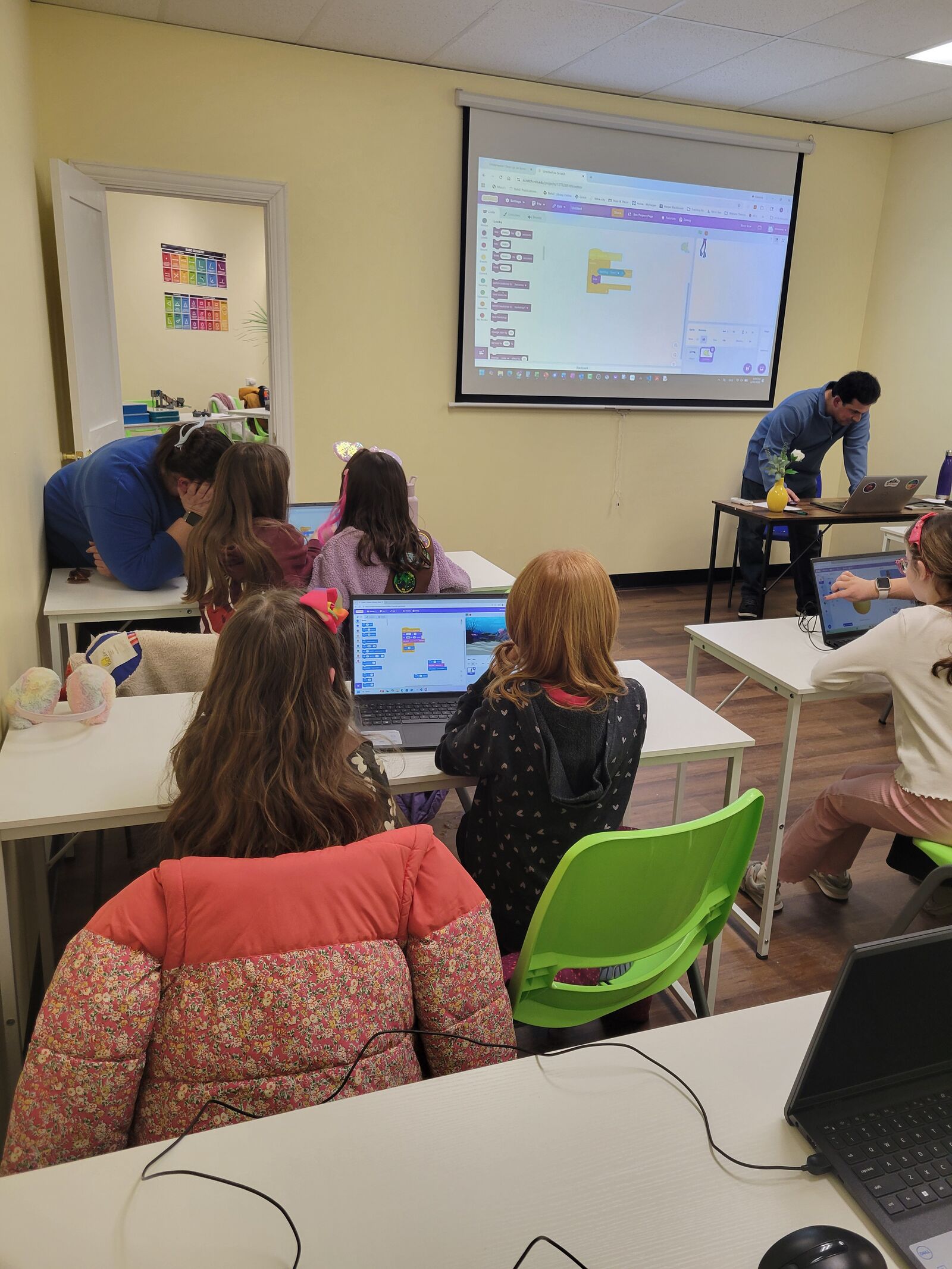 A coding class following a block-coding lesson on the projector